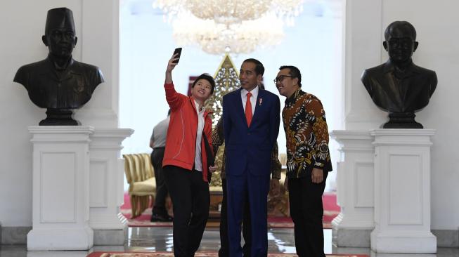 Presiden Joko Widodo (tengah) berswafoto bersama Menteri Pemuda dan Olahraga Imam Nahrawi (kanan) dan atlet bulutangkis Liliyana Natsir (kiri) di Istana Merdeka, Jakarta, Selasa (29/1). ANTARA FOTO/Puspa Perwitasari