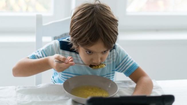 Anak Makan Sambil Nonton Video di Gawai. (Shutterstock)