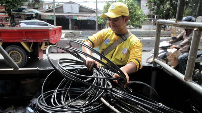 Petugas Bina Marga Jakarta Selatan melakukan penertiban jaringan kabel utilitas yang semrawut di kawasan Warung Jati Barat, Jakarta Selatan, Rabu (30/1).[Suara.com/Fakhri Hermansyah]
