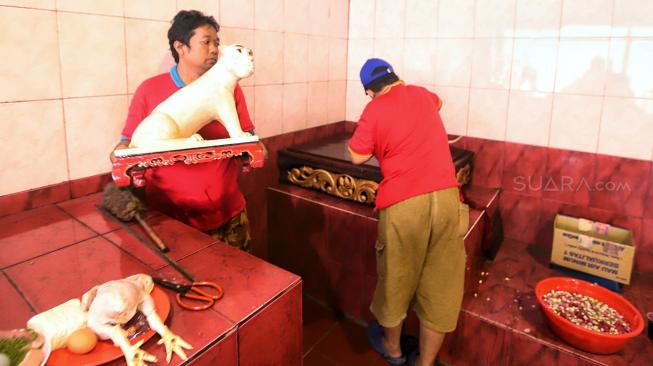 Pengelola bersama warga membersihkan patung dewa di Vihara Dharma Bhakti, Glodok, Jakarta, Rabu (30/1).[Suara.com/Muhaimin A Untung]