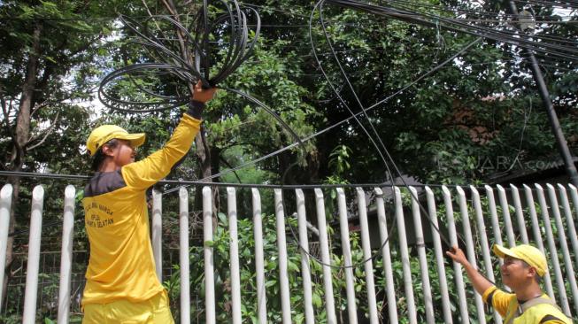 Petugas Bina Marga Jakarta Selatan melakukan penertiban jaringan kabel utilitas yang semrawut di kawasan Warung Jati Barat, Jakarta Selatan, Rabu (30/1).[Suara.com/Fakhri Hermansyah]

