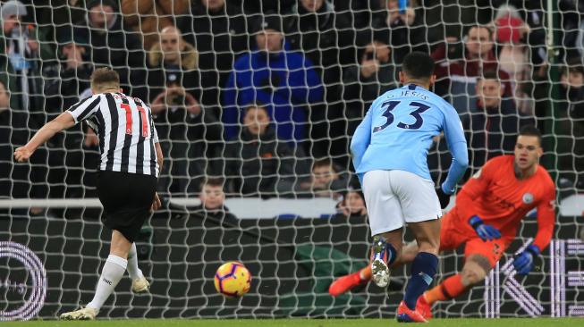 Gelandang Newcastle United, Matt Ritchie mencetak gol kedua dari titik penalti melewati kiper Manchester City Ederson selama pertandingan sepak bola Liga Primer Inggris antara Newcastle United melawan Manchester City di St James 'Park Inggris, Rabu (30/1) dini hari WIB. [Lindsey PARNABY / AFP]