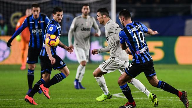 Pemain depan Juventus Cristiano Ronaldo mencoba melewati bek Atalanta Albania Berat Djimsiti selama pertandingan lanjutan Coppa Italia antara Atalanta melawan Juventus di Stadion Atleti Azzuri d'Italia, Bergamo, Italia, Kamis (31/1) dini hari WIB. [Miguel MEDINA / AFP]