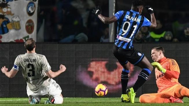 Bek Juventus Giorgio Chiellini mencoba menghambat pemain depan Atalanta Duvan Zapata (tengah) di laga Coppa Italia. Miguel MEDINA / AFP