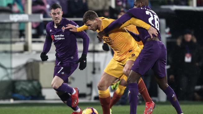 Pemain depan AS Roma Edin Dzeko dihadang oleh gelandang Fiorentina Edimilson Fernandes selama pertandingan lanjutan Coppa Italia antara Fiorentina melawan AS Roma di Stadion Artemio Franchi, Florence, Italia, Kamis (31/1) dini hari WIB. [Isabella BONOTTO / AFP]