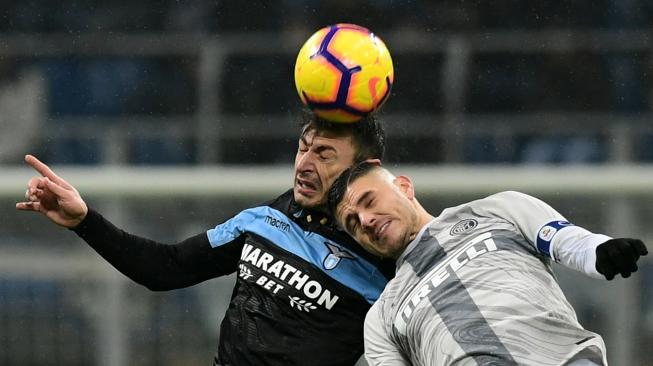 Bek Lazio Stefan Radu dan pemain depan Inter Milan Mauro Icardi melakukan sundulan dalam pertandingan lanjutan Coppa Italia antara Inter Milan melawan Lazio di Stadion Giuseppe Meazza, Milan, Italia, Jumat (1/2). [Miguel MEDINA / AFP]
