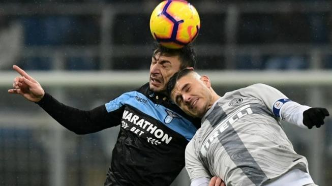 Bek Lazio, Stefan Radu (kiri), berduel udara dengan penyerang Inter Milan, Mauro Icardi, saat kedua tim bertemu dalam babak perempat final Coppa Italia di Giuseppe Meazza, Kamis (31/1/2019). [AFP/Miguel Medina]