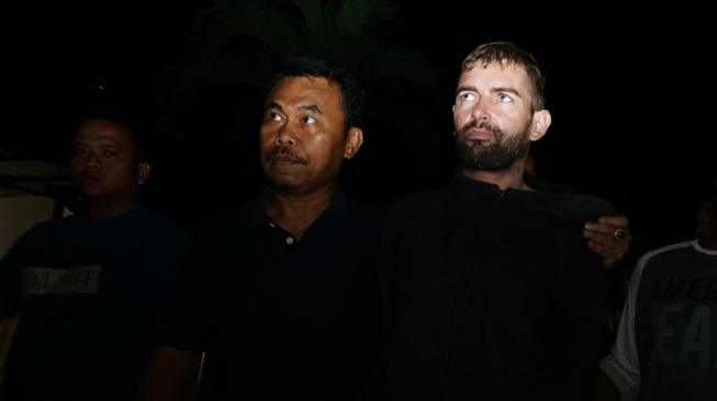 Tahanan Polda NTB Dorfin Felix (kedua kanan) dibawa petugas kepolisian ketika tiba di Mapolda NTB, Jumat (1/2). [ANTARA FOTO/Dhimas B. Pratama]