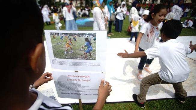 Seorang siswa memperhatikan gambar permainan Gobak Sodor/Galasin di lapangan Wali Kota Depok, Jawa Barat, Sabtu (2/2).  [ANTARA FOTO/Kahfie Kamaru]