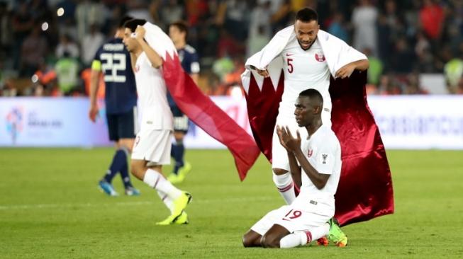 Almoez Ali (kanan) bersyukur setelah membawa Qatar meraih juara Piala Asia 2019 setelah mengalahkan Jepang di final di Mohammed Bin Zayed Stadium, Abu Dhabi. Karim Sahib / AFP