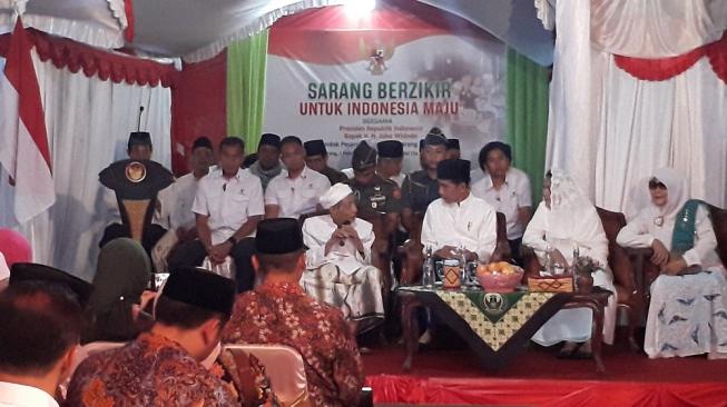 Pimpinan Pondok Pesantren Al-Anwar Sarang, KH Maimun Zubair duduk di samping Presiden Joko Widodo (Jokowi) dalam acara Sarang Berzikir Indonesia Maju di Rembang, Jawa Tengah, Jumat (1/2). [Suara.com/Ummi Hadyah Saleh]