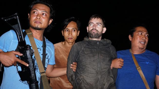 Tahanan Polda NTB Dorfin Felix (kedua kanan) dibawa petugas kepolisian ketika tiba di Mapolda NTB, Jumat (1/2). [ANTARA FOTO/Dhimas B. Pratama]