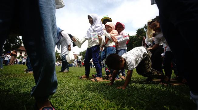 Sejumlah siswa mencoba permainan Bakiak di lapangan Wali Kota Depok, Jawa Barat, Sabtu (2/2). [ANTARA FOTO/Kahfie Kamaru]
