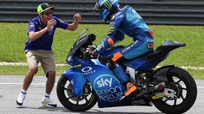 Valentino Rossi (kiri) merayakan keberhasilan adik tirinya, Luca Marini, memenangi balapan Moto2 Malaysia 2018 di Sirkuit Sepang, Minggu (4/11/2018). [AFP/Mohd Rasfan]