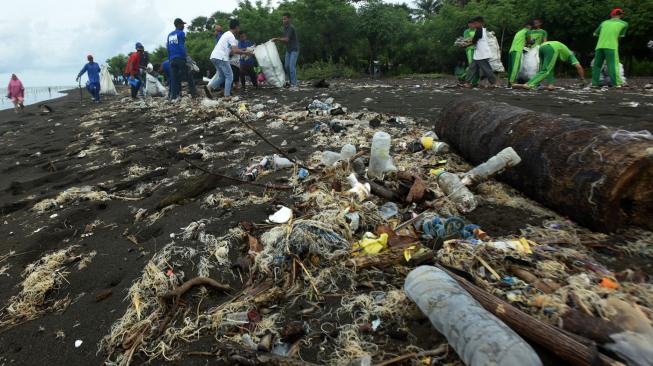 Relawan dari Invest Co-op Indonesia memungut sampah saat melakukan Aksi Pantai Kami Bersih di Pantai Ujung Baji, Takalar, Sulawesi Selatan, Sabtu (2/2). ANTARA FOTO/Yusran Uccang