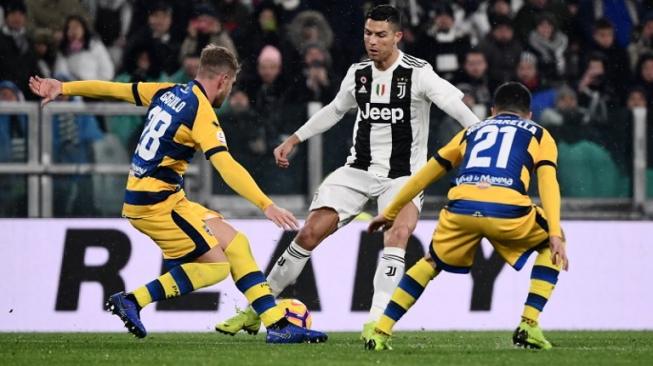 Bintang Juventus, Cristiano Ronaldo, dihadang dua pemain Parma, Riccardo Gagliolo (kiri) dan Matteo Scozzarella, dalam lanjutan Liga Italia pekan ke-22 di Juventus Arena, Sabtu (2/2/2019) atau Minggu dini hari WIB. [AFP/Marco Bertorello]