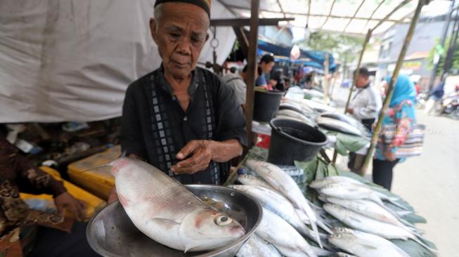 Warga membeli ikan bandeng di Pasar Rawa Belong, Jakarta, Minggu (3/1). [Suara.com/Muhaimin A Untung]