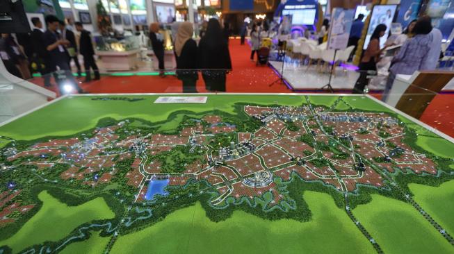 Pengunjung melintas di dekat maket sebuah apartemen pada Indonesia Property Expo (IPEX) 2019 di Jakarta Convention Centre (JCC), Jakarta, Senin (4/2). [Suara.com/Muhaimin A Untung]