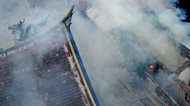 Petugas berusaha memadamkan api yang membakar Vihara Samudra Bhakti di Bandung, Jawa Barat, Selasa (5/2). [ANTARA FOTO/Raisan Al Farisi]
