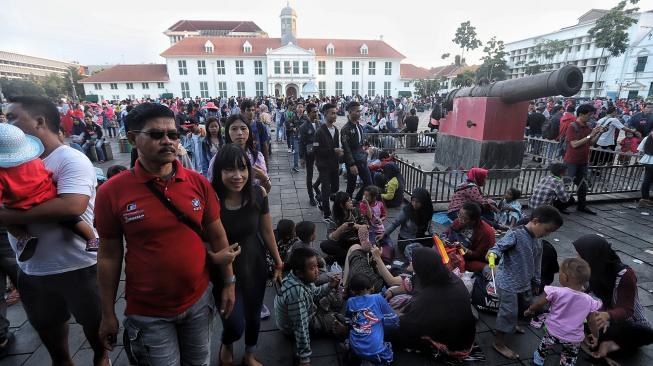 Wisatawan menikmati suasana Kawasan Kota Tua Jakarta, Selasa (5/2). [Suara.com/Muhaimin A Untung]