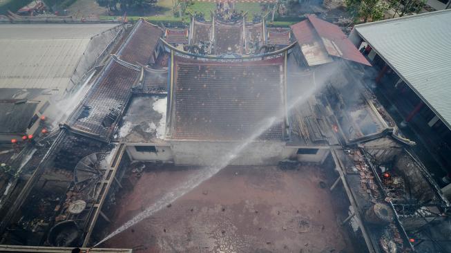 Petugas berusaha memadamkan api yang membakar Vihara Samudra Bhakti di Bandung, Jawa Barat, Selasa (5/2). [ANTARA FOTO/Raisan Al Farisi]