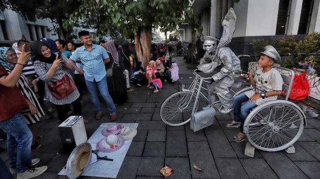 Wisatawan menikmati suasana Kawasan Kota Tua Jakarta, Selasa (5/2). [Suara.com/Muhaimin A Untung]