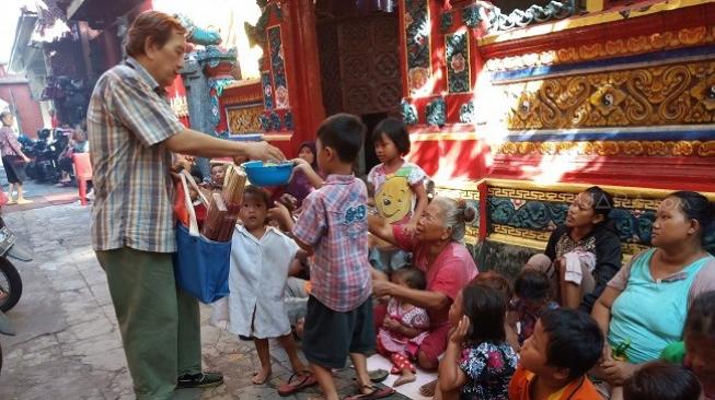 Bagi-bagi angpao di Kelenteng Hong Tiek Hian, Surabaya. (Suara.com/Achmad Ali)