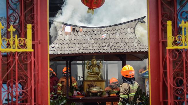 Petugas berusaha memadamkan api yang membakar Vihara Samudra Bhakti di Bandung, Jawa Barat, Selasa (5/2). [ANTARA FOTO/Raisan Al Farisi]
