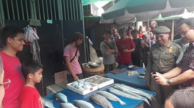 Anies Jadikan Dua Anaknya Model untuk Foto dengan Ikan di Pasar