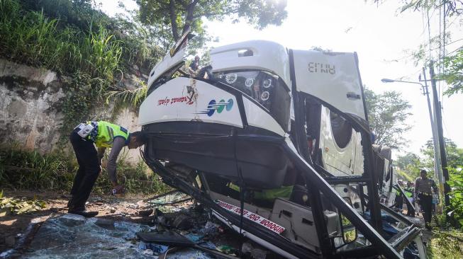 Petugas kepolisian melakukan olah tempat kejadian perkara kecelakaan bus Kramat Djati di Cikopo, Cicalengka, Kabupaten Bandung, Jawa Barat, Rabu (6/2). [ANTARA FOTO/Raisan Al Farisi]