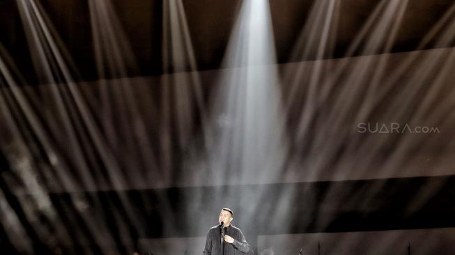 Penyanyi Tulus saat bernyanyi menghibur di Konser Monokrom Tulus di Istora Senayan, Jakarta, (6/2). [Suara.com/Muhaimin A Untung]