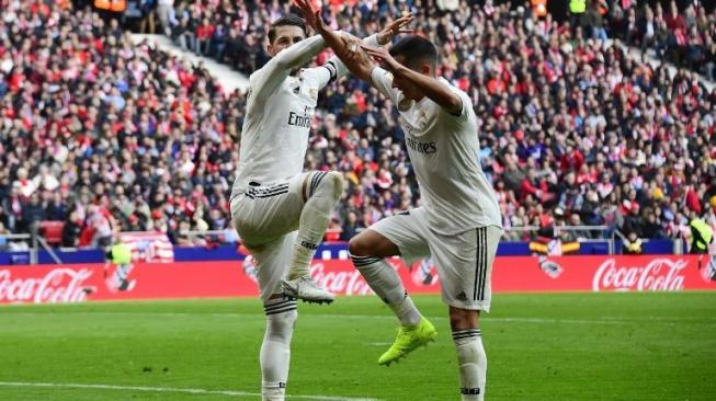 Bek Real Madrid Sergio Ramos (kiri) merayakan golnya dari titik penalti ke gawang Atletico Madrid dengan rekan setimnya Lucas Vazquez. GABRIEL BOUYS / AFP