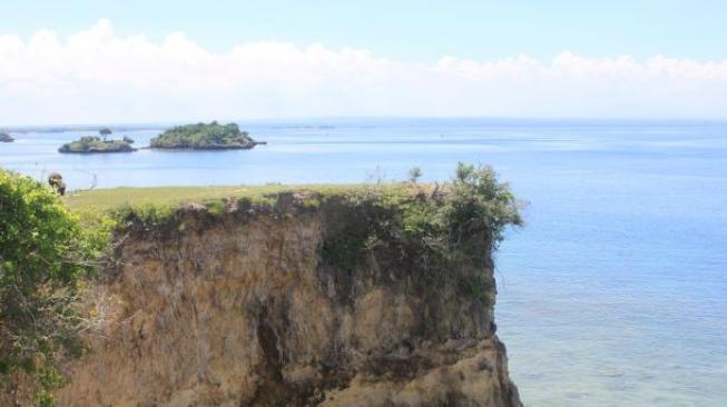 Pemandangan pulau dan perbukitan di sekitar Pink Beach. (Suara.com/Silfa Humairah)