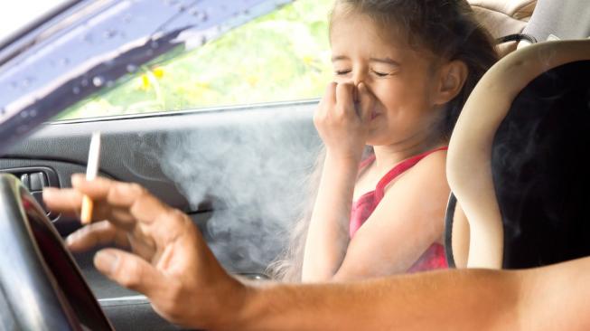 Asap rokok mengganggu pernapasan, termasuk anak-anak yang usianya rentan saat terpaksa menghirupnya. Asap juga akan mengendap atau tertinggal di seisi kabin. [Shutterstock]. 
