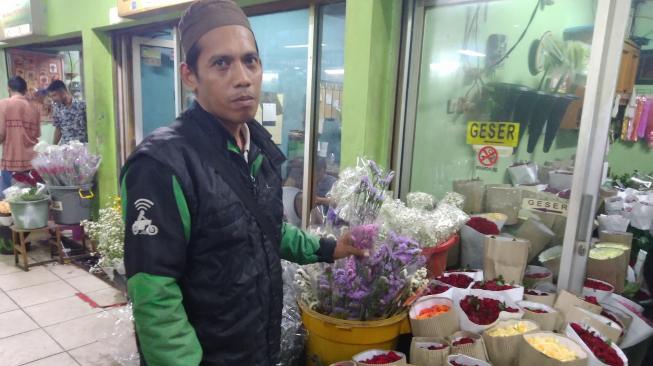 Muhammad Nur (42), pengemudi ojol yang menjemput dan antarkan pesanan bunga jelang Hari Valentine [Suara.com/Stephanus Aranditio].