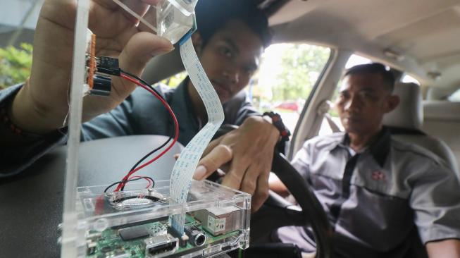 Mahasiswa Stikom menunjukkan prototipe pendeteksi mata kantuk pengendara mobil bernama Si Dekan hasil karyanya di Surabaya, Jawa Timur, Rabu (13/2). [ANTARA FOTO/Didik Suhartono]