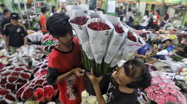 Warga membeli bunga di Pasar Rawa Belong, Jakarta, Kamis (14/2). [Suara.com/Muhaimin A Untung]
