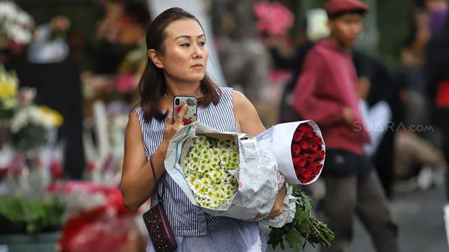 Warga membeli bunga di Pasar Rawa Belong, Jakarta, Kamis (14/2). [Suara.com/Muhaimin A Untung]
