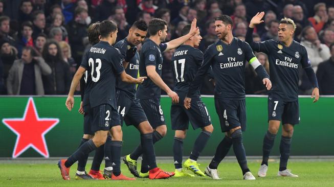 Para pemain Real Madrid merayakan gol kedua mereka selama pertandingan leg pertama babak 16 besar Liga Champions antara Ajax Amsterdam melawan Real Madrid di Johan Cruijff Arena, Amsterdam, Belanda, Kamis (14/2) dini hari WIB. [EMMANUEL DUNAND / AFP]