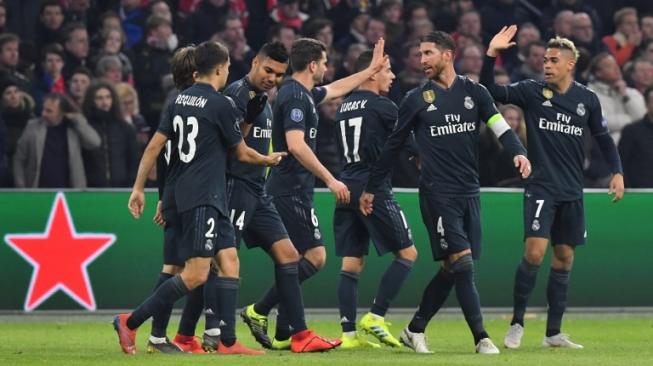 Para pemain Real Madrid merayakan gol Marco Asensio ke gawang Ajax Amsterdam di Johan Cruijff Arena di leg pertama babak 16 besar Liga Champions. EMMANUEL DUNAND / AFP