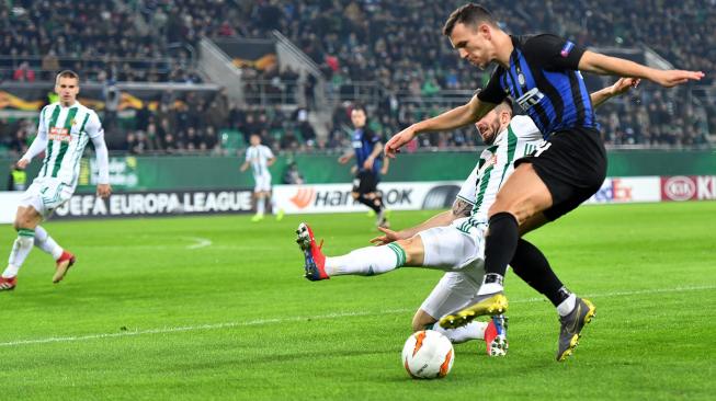 Pemain Rapid Vienna Marvin Potzmann (kiri) dan pemain Inter, Ivan Perisic, berlomba merebut bola pada leg pertama 32 besar Liga Europa  antara Rapid Vienna melawan Inter Milan di Allianz Stadion, Wina, Austria, Jumat (15/2) dini hari WIB. (AFP/Joe Klamar)