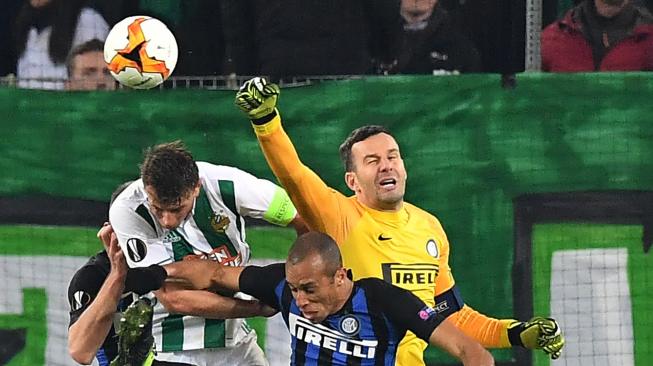 Pemain Rapid Vienna Stefan Schwab (kiri) memperebutkan bola dengan Samir Handanovic (kanan) dari Inter dan Joao Miranda dari Inter pada leg pertama 32 besar Liga Europa  antara Rapid Vienna melawan Inter Milan di Allianz Stadion, Wina, Austria, Jumat (15/2) dini hari WIB. (AFP/Joe Klamar)