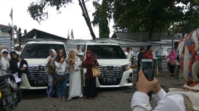 Emak-emak berswafoto di mobil Alphard capres nomor urut 02 Prabowo Subianto. (Suara.com/Adam Lyasa)