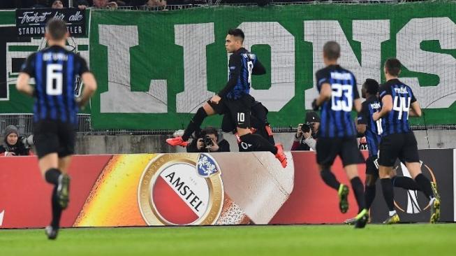 Pemain Inter Milan Lautaro Martinez (tengah) merayakan golnya ke gawang Rapid Viena dari titik penalti di leg pertama babak 32 besar Liga Europa. JOE KLAMAR / AFP