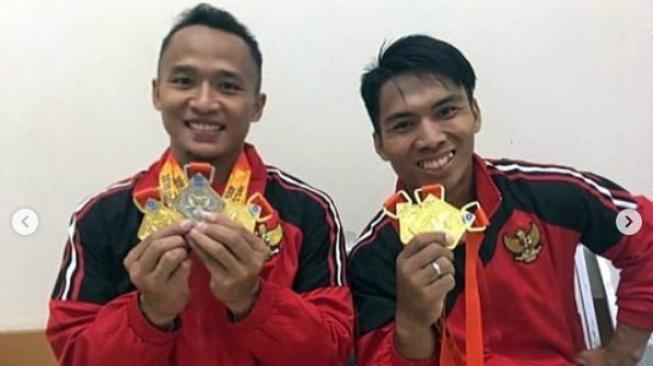 Lifter Indonesia, Triyatno (kiri) dan Deni, memamerkan medali emas yang didapat dari ajang EGAT's Cup International Weightlifting Championship di Chiang Mai, Thailand. [Instagram@nahrawi_imam]