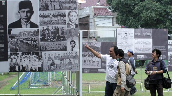 Pengunjung mengamati pameran foto sejarah MH Thamrin, Politik, dan sepak bola kebangsaan di Stadion Vij, Cideng, Jakarta Pusat, Sabtu (16/2). [Suara.com/Fakhri Hermansyah]
