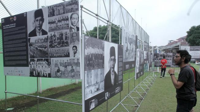 Pengunjung mengamati pameran foto sejarah MH Thamrin, Politik, dan sepak bola kebangsaan di Stadion Vij, Cideng, Jakarta Pusat, Sabtu (16/2). [Suara.com/Fakhri Hermansyah]