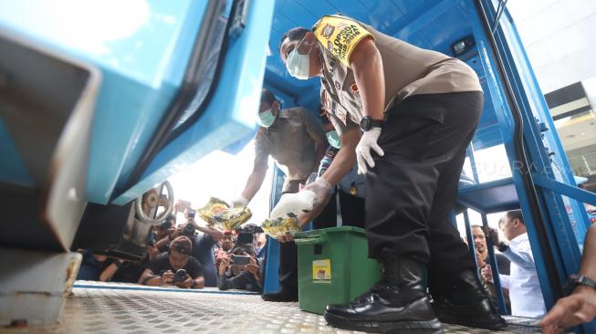 Kapolda Metro Jaya Irjen Pol Gatot Eddy Pramono didampingi Wakil Kepala Kejaksaan Tinggi DKI Jakarta Pathor Rahman memasukkan barang bukti narkotika ke mesin penghancur saat konferensi pers pemusnahan di Polda Metro Jaya, Jakarta, Senin (18/2). [Suara.com/Muhaimin A Untung]