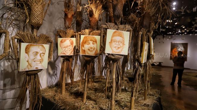 Pengunjung melihat karya Perupa Hari Budiono saat pameran Memedi Sawah di Bentara Budaya Jakarta, Jakarta, Senin (18/2). [Suara.com/Muhaimin A Untung] 