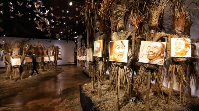 Pengunjung melihat karya Perupa Hari Budiono saat pameran Memedi Sawah di Bentara Budaya Jakarta, Jakarta, Senin (18/2). [Suara.com/Muhaimin A Untung] 